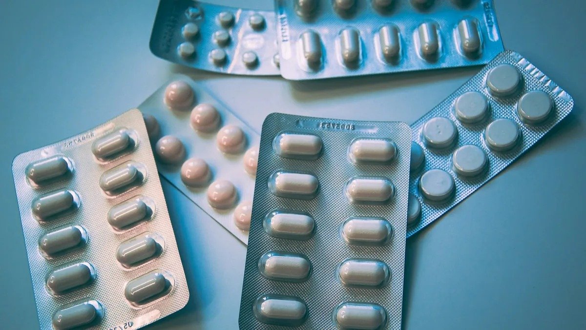 Photographic close-up of pharmaceutical blister packs with white tablets on a teal surface, news thumbnail for thyroid medication recall coverage
